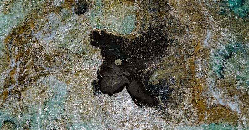 Budget Travel - A small black rock in the middle of the ocean